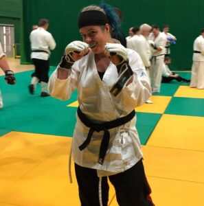 A picture of the instructor, Emma. She is wearing MMA boxing gloves and is about to start sparring.