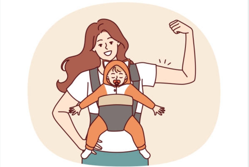 A picture of a woman with a baby in a sling. The woman is flexing her muscles.